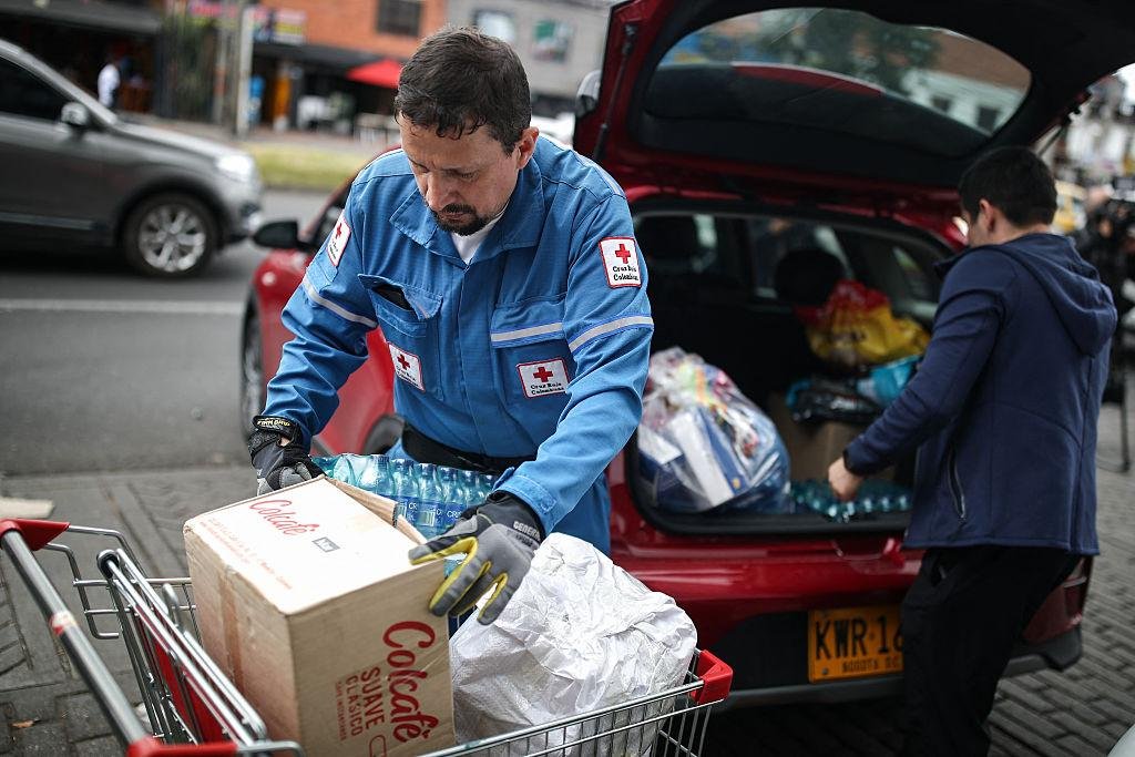 Voluntario cargando cajas de agua y alimentos para su entrega
